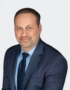 Chad C. Silver, Criminal and Tax Attorney at Sullivan for IRS Matters, smiling confidently in professional attire within a modern office environment.