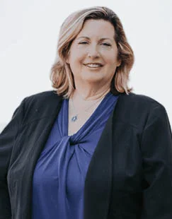 Jennifer Ginther, a tax advisor at Sullivan for IRS Matters, smiling confidently in professional attire during a client consultation in a modern office setting.